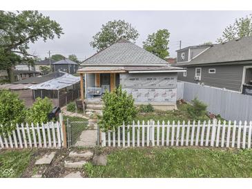 Exterior view of a home with a white picket fence and a partially renovated front facade at 952 Lasalle St, Indianapolis, IN 46201