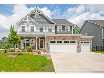 Charming two-story home featuring stone accents, a welcoming porch, and a three-car attached garage at 1026 Woodglen Dr, Westfield, IN 46074