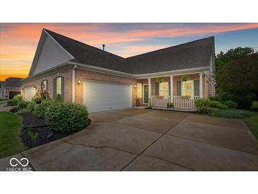 Charming brick home with an attached garage, inviting front porch, and well-manicured landscaping at 1905 Persimmon Grove Dr, Indianapolis, IN 46234