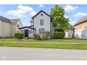 Charming home featuring a white exterior with black trim and a well-manicured lawn at 2111 S A St, Elwood, IN 46036