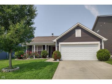 Inviting single-story home with manicured lawn, flowering bushes, and a two-car garage at 2432 Bridlewood Dr, Franklin, IN 46131