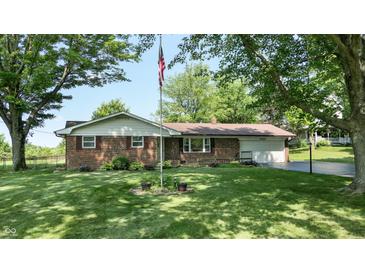 Charming brick home with well-manicured lawn, mature trees, and an American flag at 4124 Five Points Rd, Indianapolis, IN 46239