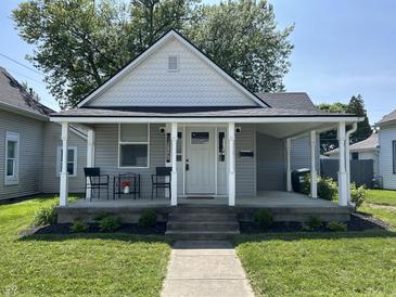 Charming home features a welcoming front porch perfect for enjoying the outdoors and a tidy, landscaped front yard at 420 S Oak St, Fortville, IN 46040