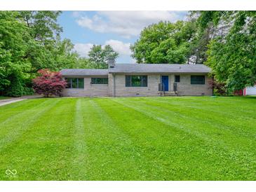Charming stone home with a well-maintained lawn and mature trees at 4853 E 65Th St, Indianapolis, IN 46220