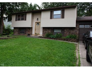 Split-level home featuring neutral siding, brick accents, and a well-maintained green lawn at 7402 Broadview Dr, Indianapolis, IN 46227