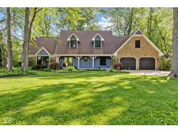 Charming two-story home with a well-manicured lawn, blue siding, stone accents, and a three-car garage at 7630 Blain Way, Indianapolis, IN 46254