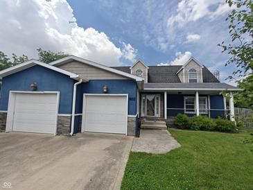 Charming blue two-story home with a landscaped front yard and an attached two-car garage at 802 Fern Dr, Shelbyville, IN 46176