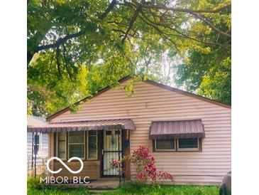 Charming one-story house with mature trees and awning covered porch and windows at 1143 Sharon Ave, Indianapolis, IN 46222