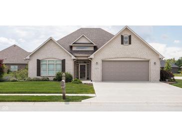 Beautiful single-Gathering home featuring a gray brick exterior, well-manicured lawn, and two-car garage at 1227 Highbury Dr, Danville, IN 46122