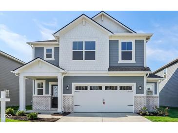 Two-story home boasts a white garage door, stylish gray siding, and a welcoming front porch at 1669 Windrush Pl, Westfield, IN 46074