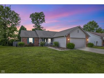 Charming single-story home with brick accents, well-manicured lawn, and cozy front porch at twilight at 34 Westview Pl, Bargersville, IN 46106