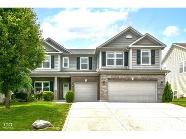 Charming two-story home featuring a well-manicured lawn and a two-car garage with an appealing stone and brick facade at 4650 Blue Marlin Way, Indianapolis, IN 46239