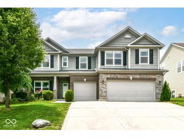 Charming two-story home with a well-manicured lawn, two-car garage, and beautiful stone and siding exterior at 4650 Blue Marlin Way, Indianapolis, IN 46239
