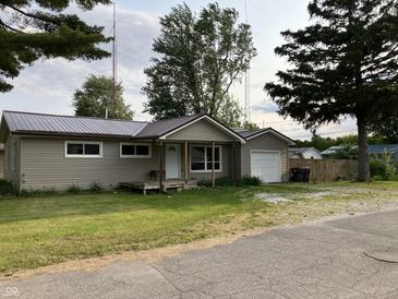 Charming single-story home with vinyl siding, metal roof and attached one car garage at 501 W Taylor St, Alexandria, IN 46001