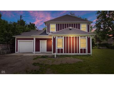 Charming two-story home with a classic design, featuring a detached garage and well-lit exterior against a lovely sky at 541 Dayton Ave, Indianapolis, IN 46203