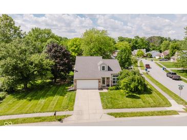 Charming two-story home with a well-manicured lawn and a lovely tree-lined street at 7402 Northfield Blvd, Fishers, IN 46038