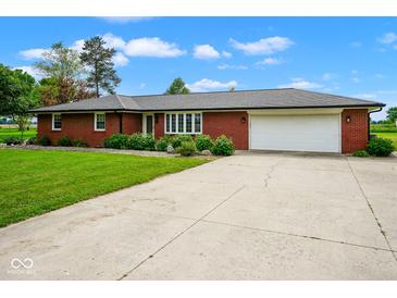 Charming single-story brick home with a well-maintained lawn and a spacious two-car garage at 7447 S 25 E, Pendleton, IN 46064
