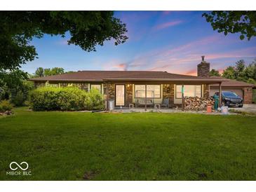 Charming single story home featuring a covered front porch and a sprawling green lawn at 8244 E Hadley Rd, Camby, IN 46113