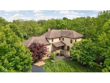 Majestic home featuring a brown tile roof surrounded by lush greenery at 9601 Irishmans Run Ln, Zionsville, IN 46077