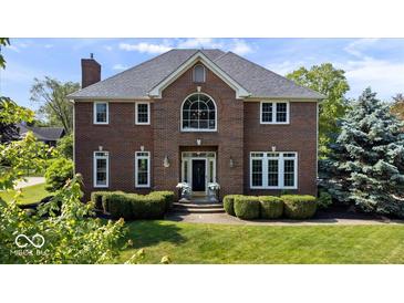 Beautiful brick two-story home with manicured lawn and mature landscaping at 9973 Woods Edge Dr, Fishers, IN 46037