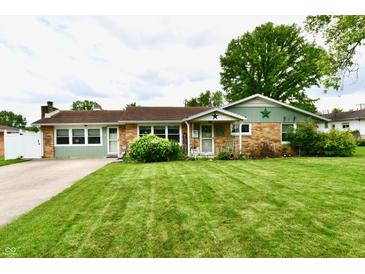 Charming single-story home with well-manicured lawn and inviting front porch at 121 Mulberry Dr, Chesterfield, IN 46017