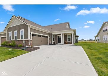 Beautiful home featuring an attached garage, brick accents, and a covered front porch at 14848 Stonneger St, Westfield, IN 46074