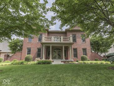Stately brick home featuring a manicured lawn, mature trees, and a charming front porch with columns at 20 Forrests Edge Ct, Indianapolis, IN 46227
