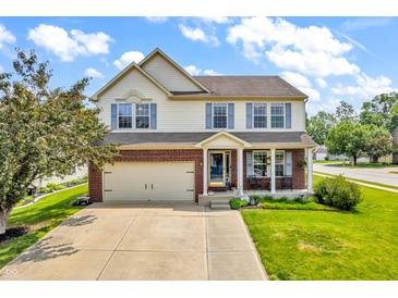 Inviting two-story home boasts blue shutters, brick accents, manicured lawn, and a welcoming front porch at 4157 Taunton Ct, Plainfield, IN 46168