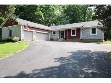 Charming home featuring stone accents, red siding, attached two-car garage, and a circular driveway at 5654 Paradise Dr, Martinsville, IN 46151