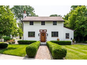 Charming two-story home featuring a brick-accented entryway and beautifully landscaped front yard with manicured hedges at 5805 Forest Ln, Indianapolis, IN 46220