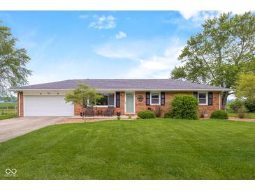 Charming brick home featuring a well-manicured lawn and inviting front porch seating area at 762 N Dellasburg Rd, Columbus, IN 47203