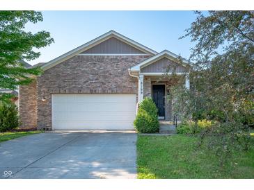 Charming brick home featuring an attached two-car garage and well-maintained landscaping at 8199 Sydney Ln, Avon, IN 46123