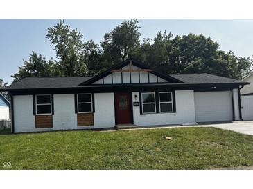 Charming home featuring a painted brick exterior, black trim, a red front door, and a well-manicured lawn at 8445 Montery Rd, Indianapolis, IN 46226