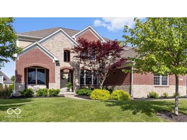 Charming two-story home features a combination brick and stone facade, professional landscaping, and a welcoming entryway at 10054 Win Star Way, Fishers, IN 46040