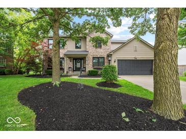 Charming two-story home with a brick and vinyl exterior, black mulch beds, and well-manicured lawn at 11987 Quarry Ct, Fishers, IN 46037