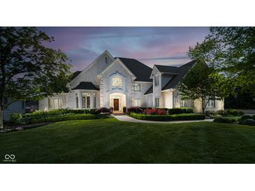 Stunning stone home with lush lawn, landscaping, and meticulous front garden at 12192 Woods Bay Pl, Carmel, IN 46033