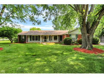 Charming ranch home with a well-maintained lawn and beautiful mature trees at 13172 E 116Th St, Fishers, IN 46037