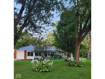 Charming brick home with well-manicured lawn and landscaping, featuring a detached garage and mature trees at 1322 Greenway Dr, Anderson, IN 46011