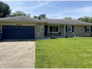 Charming single-story home with a brick facade, blue garage door, and well-manicured lawn at 4343 W Fairview Rd, Greenwood, IN 46142