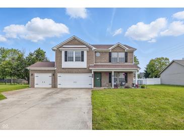 Charming two-story brick home with a three-car garage and well-manicured lawn at 5030 E 800 N, Columbus, IN 47203