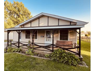 Charming single-story home featuring a quaint covered front porch with a delightful swing and tasteful landscaping at 514 W 6Th St, Sheridan, IN 46069