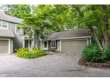 Charming home exterior featuring a lush, tree-lined yard and attached garage at 7803 Harbour, Indianapolis, IN 46240