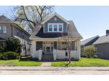 Charming blue two-story home with inviting front porch and well-maintained lawn at 831 Weghorst St, Indianapolis, IN 46203