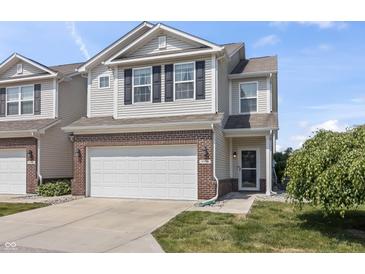 Charming two-story townhome featuring an attached garage and landscaped front yard at 9709 Prairie Smoke Dr, Noblesville, IN 46060
