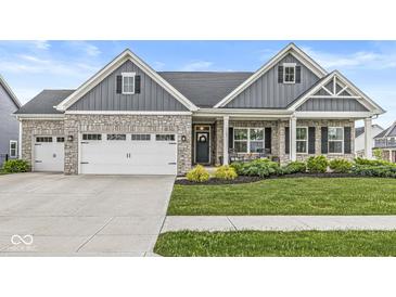 Charming exterior of a stone and gray home with a well-manicured lawn at 1107 Mccray Ln, Westfield, IN 46074