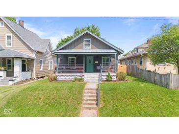 Charming home with a front porch and well-maintained lawn and inviting curb appeal at 1205 N Temple Ave, Indianapolis, IN 46201