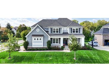 Beautiful two-story home with a well-manicured lawn and professionally landscaped yard at 14458 Smickle Ln, Carmel, IN 46033