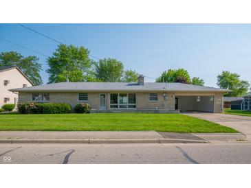 Charming single-story home featuring stone facade, well-manicured lawn, mature trees and attached carport at 1460 W Mckay Rd, Shelbyville, IN 46176