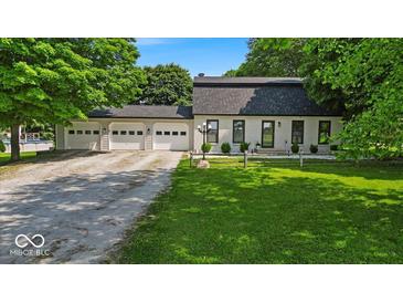 Charming painted brick home featuring a three-car garage and well-manicured lawn at 14918 E 206Th St, Noblesville, IN 46060