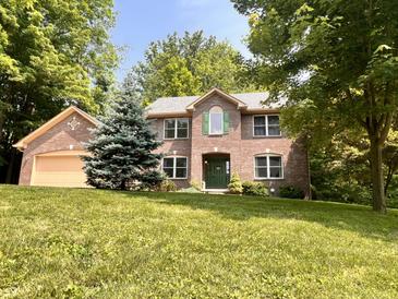 Charming brick home with a well-manicured lawn and mature trees at 2002 Grey Fox Ct, Martinsville, IN 46151